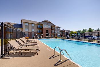 Outdoor pool at Regency Woods Apartments surrounded by lounge chairs.